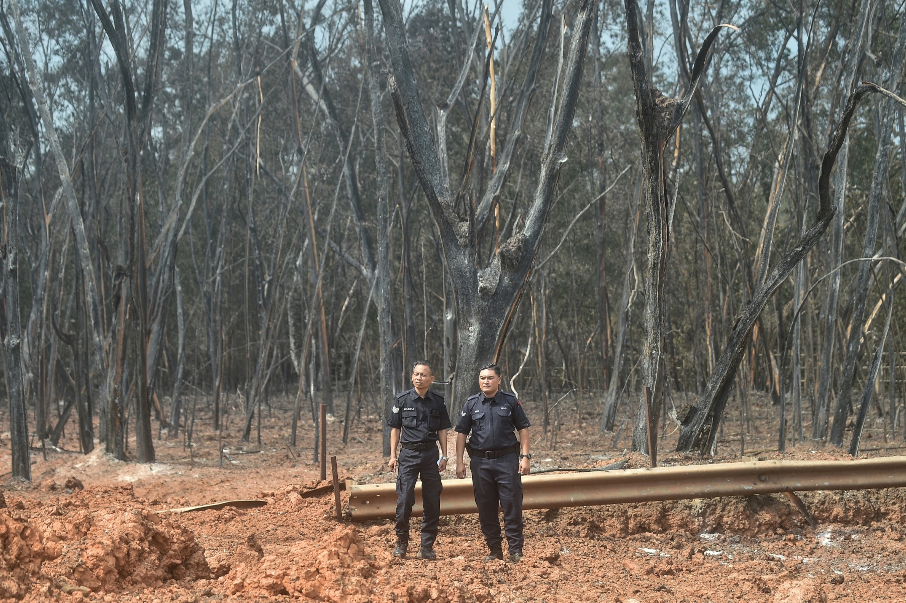 Malaysian police officers look on in a residential area following a massive gas pipeline fire in Puchong, Selangor on April 1, 2025. (AFP)