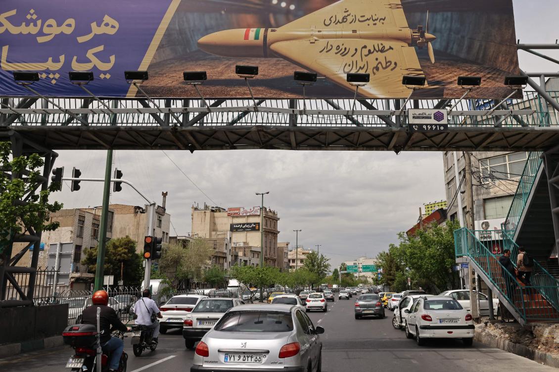 Above, motorists drive under a footbridge with a billboard reading in Persian “Every missile has a message” along a busy street in Tehran on April 19, 2026. (AFP)