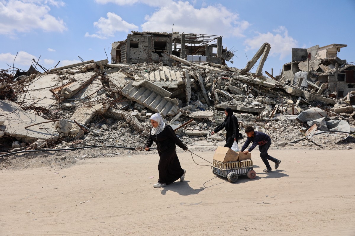 Displaced Palestinians carry boxes in a cart past the rubble of destroyed buildings at the Jabalia refugee camp in the northern Gaza Strip, April 13, 2026. (Files / AFP)