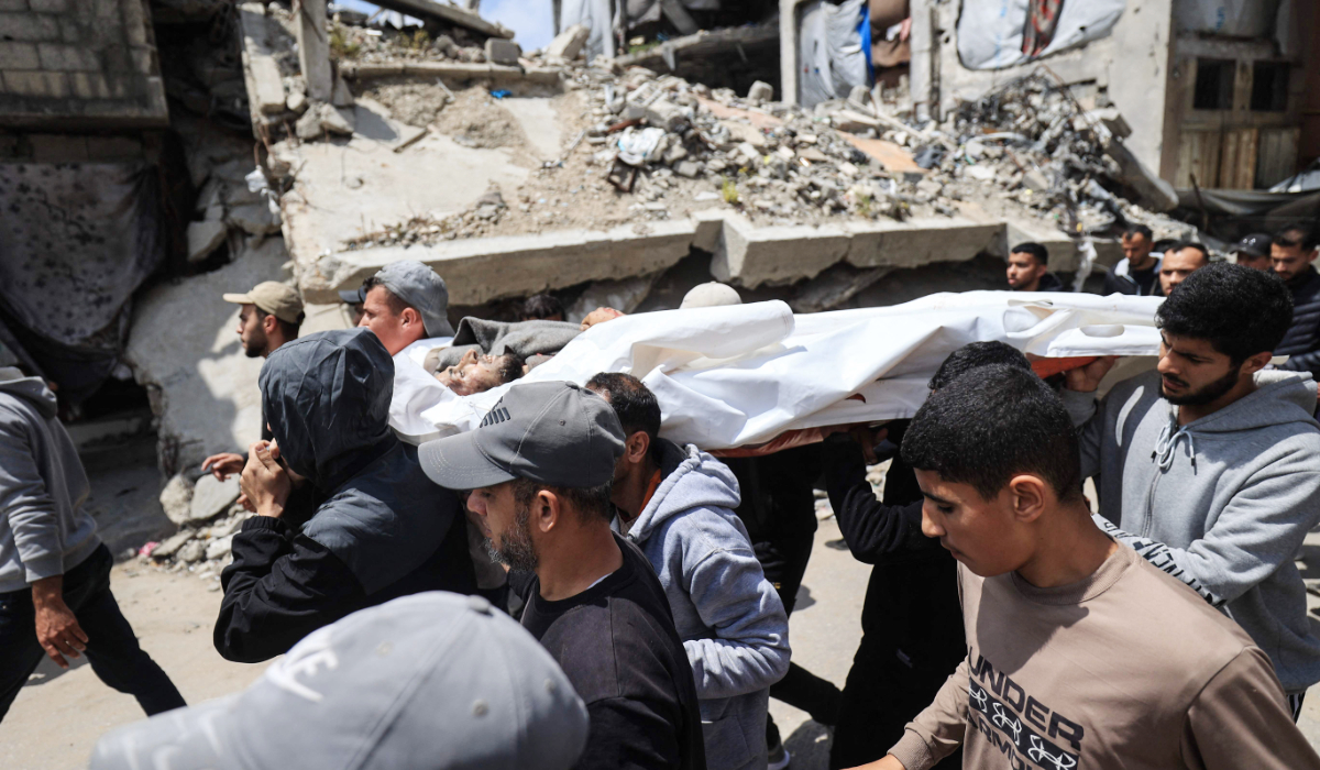 Displaced Palestinians carry the body of Ayman Abu Hasna, who was reportedly killed overnight in an Israeli strike while riding a motorcycle, during his funeral in the Bureij refugee camp in the central Gaza Strip on April 20, 2026. (AFP)