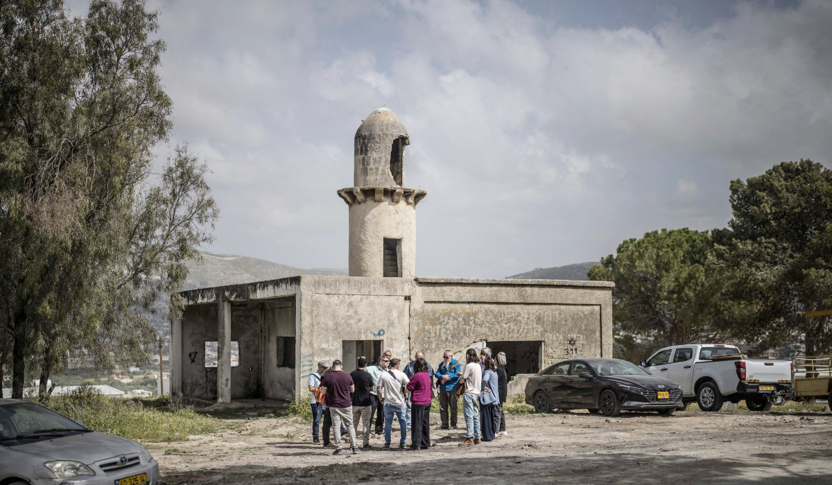 A group of Israeli settlers gather in front of the structure of a mosque at the end of the resettlement ceremony of Sa-Nur, south of Jenin in the Israeli-occupied West Bank, on April 19, 2026. (AFP)