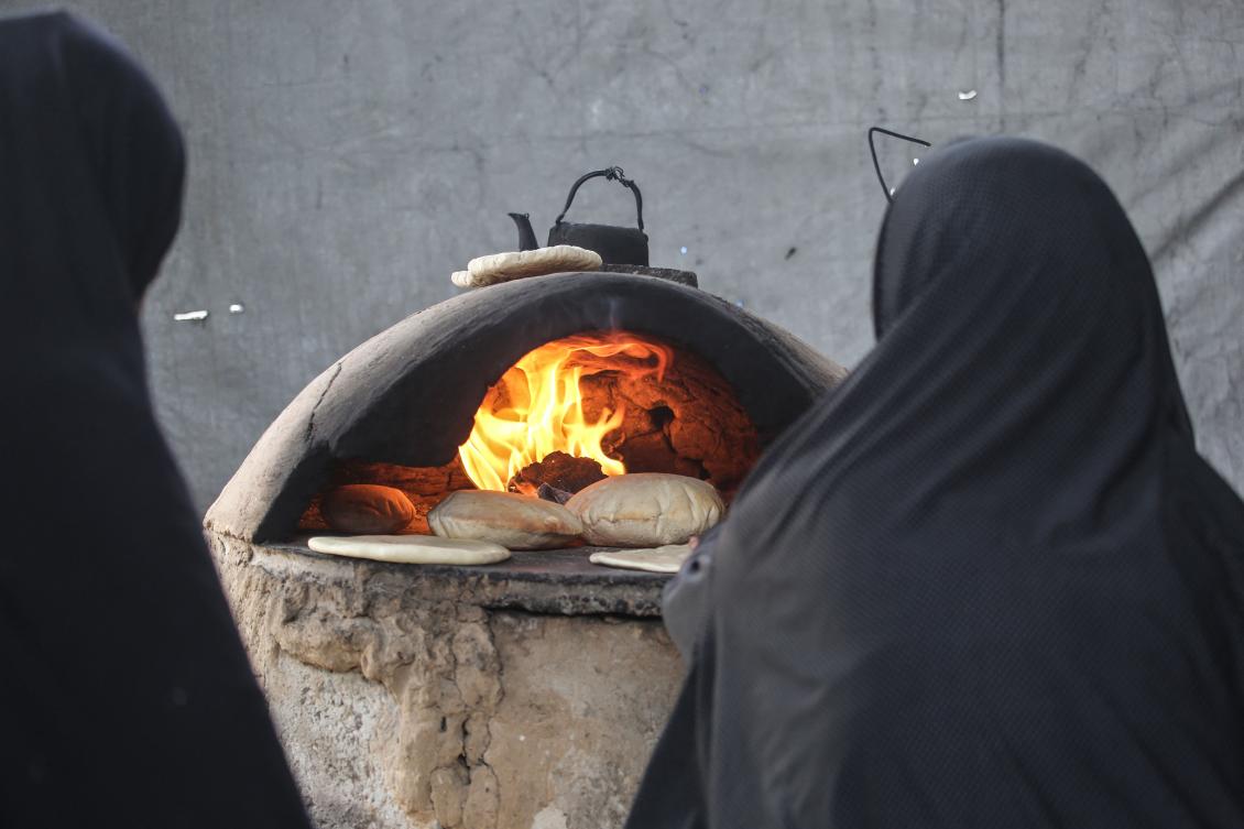 Palestinian women bake bread in a wood oven in Khan Yunis in the southern Gaza Strip on April 18, 2026. (AFP)