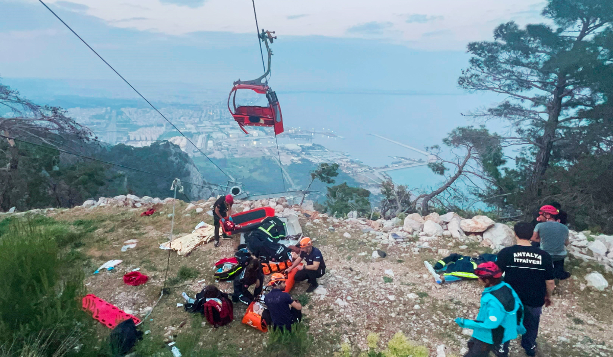 Rescue and emergency team members work with passengers of a cable car transportation system outside Antalya, southern Turkey, April 12, 2024. (AP)