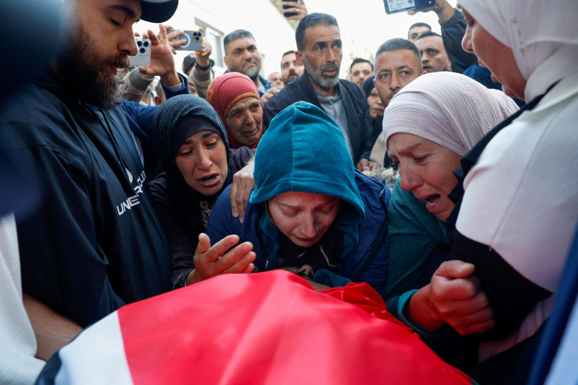 Relatives mourn over the body of a Palestinian who was killed during an Israeli settler attack in Deir Dibwan village near Ramallah on Wednesday. (Reuters)