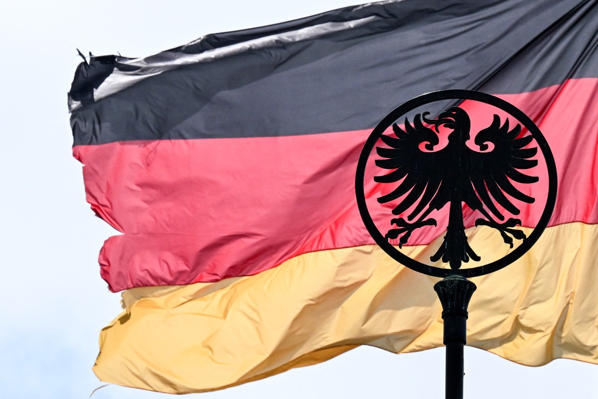 A emblem displaying an eagle is pictured in front of German national flag that flies atop an official building in Frankfurt am Main, western Germany, June 6, 2025 (Files / AFP)