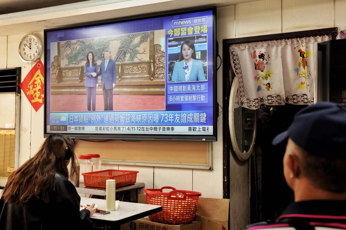 Above, a television at a restaurant in Taipei shows the meeting between Kuomintang chairwoman Cheng Li-wun and Chinese President Xi Jinping in Beijing on April 10, 2026. (AFP)