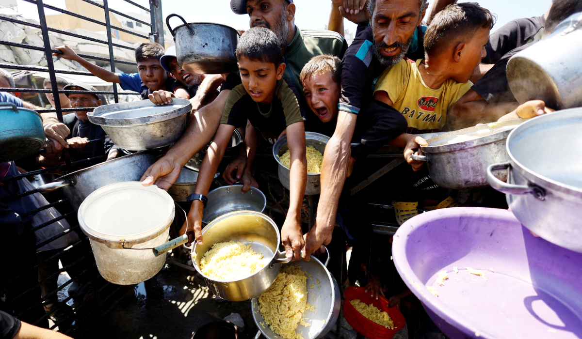 Palestinians receive food from a charity kitchen in Gaza City. The Global Report on Food Crises has highlighted famine in parts of Gaza. (Reuters)