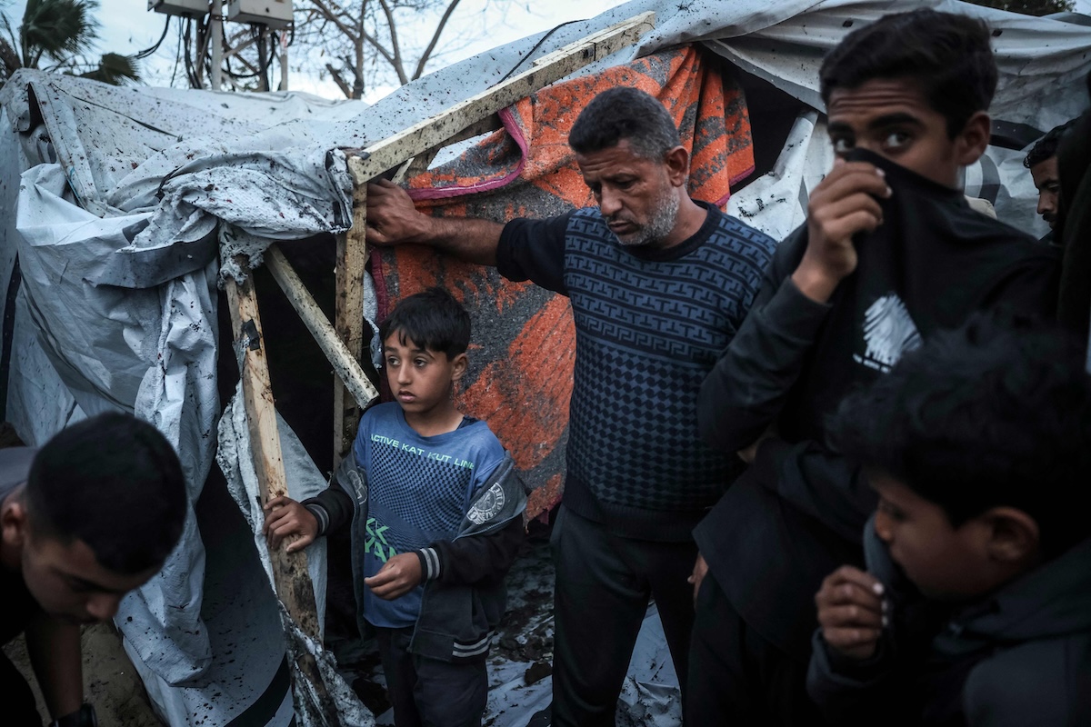People gather at the site of an Israeli strike on a police vehicle in Khan Younis, in the southern Gaza Strip on April 24, 2026. (AFP)