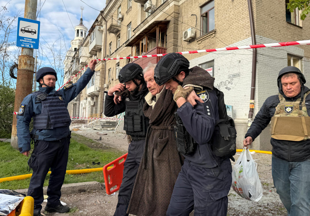 Police officers evacuate a wounded resident at a site of an apartment building hit by a Russian drone and missile strike in Dnipro, Ukraine on April 25, 2026. (Reuters)