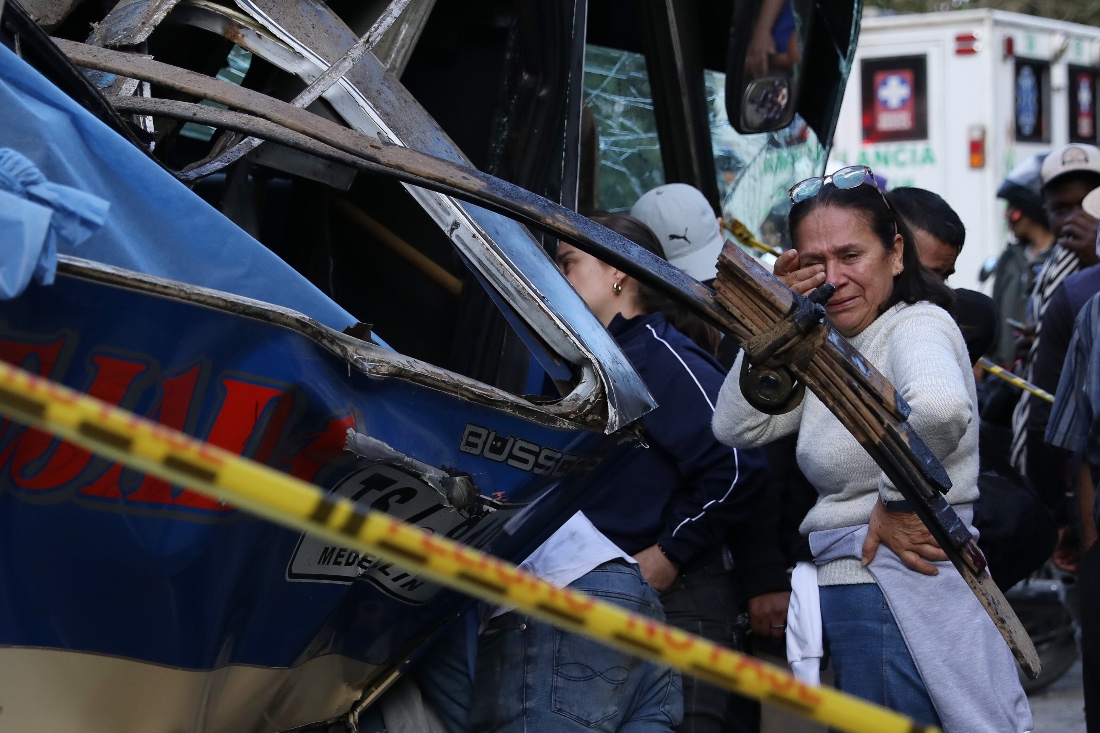 People gather around a bus hit by an explosive device on the Pan-American Highway in Cajibio, Colombia. (AP)