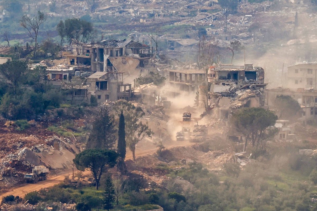 Above, Israeli tanks and military vehicles drive along the road between destroyed houses in southern Lebanon near the border with Israel, on April 25, 2026. (AFP)