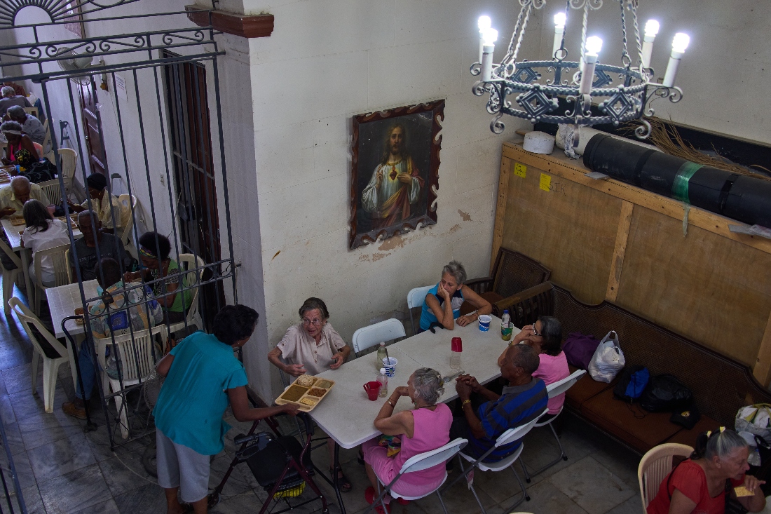 Carmen Casado, 84, is served a free meal of ground meat, rice, red beans and crackers through a program run by the Church of the Holy Spirit at a dining hall adjacent to the church in Old Havana, Cuba. (AP)
