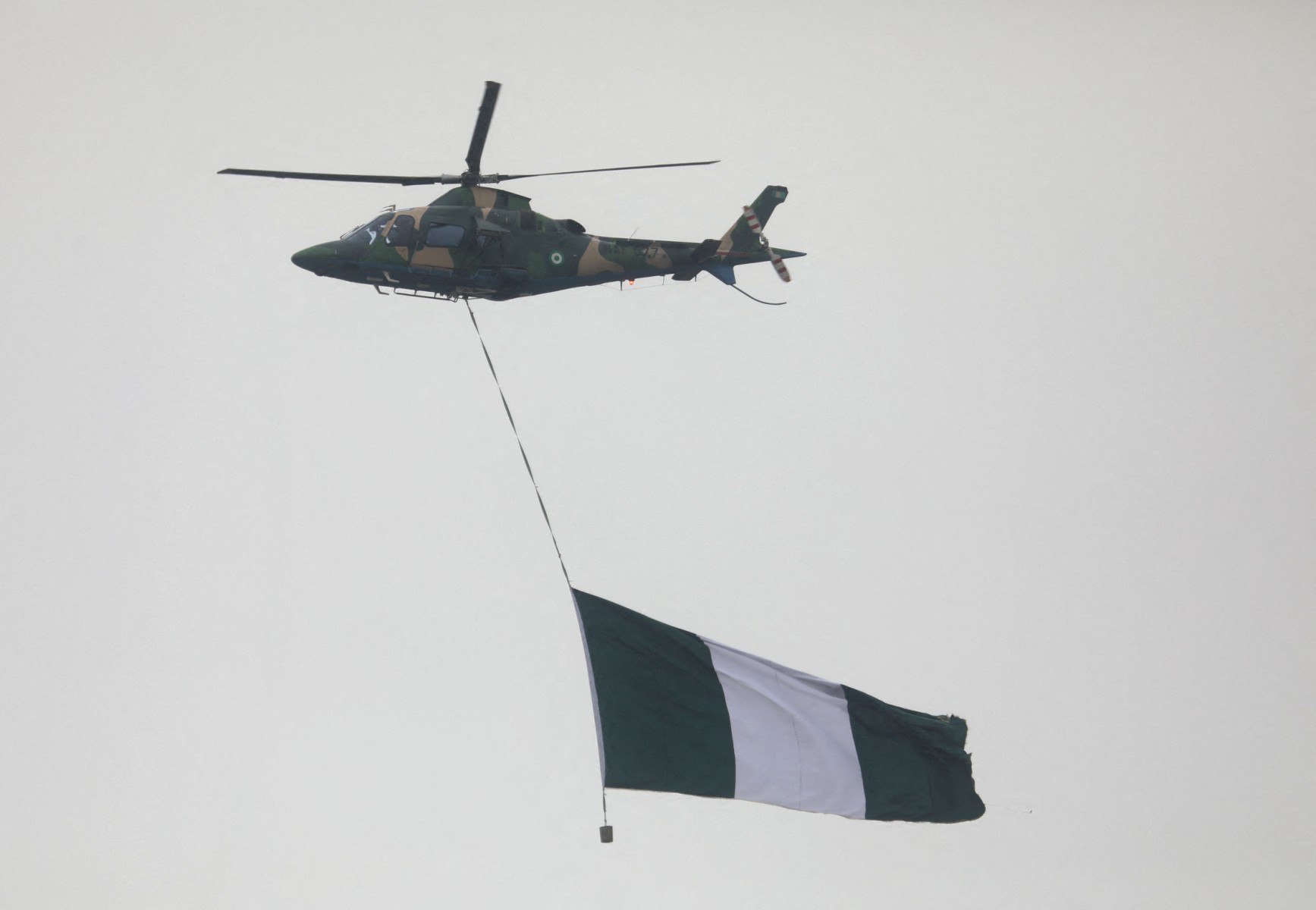 A Nigerian military helicopter carries the Nigerian flag flying over the capital, Abuja. (Files / AFP)