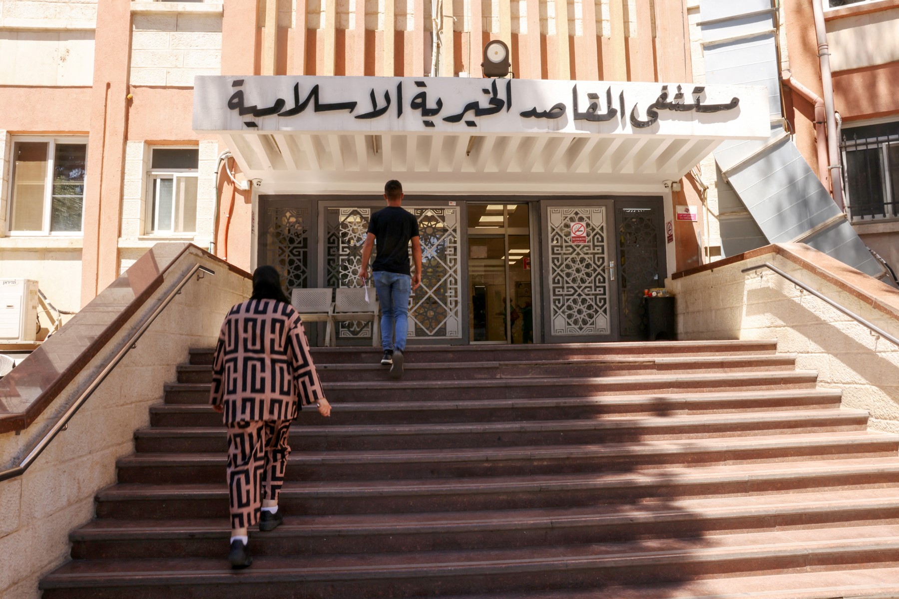 People walk towards the main entrance of Jerusalem’s Al-Maqased Hospital. (Files / AFP)