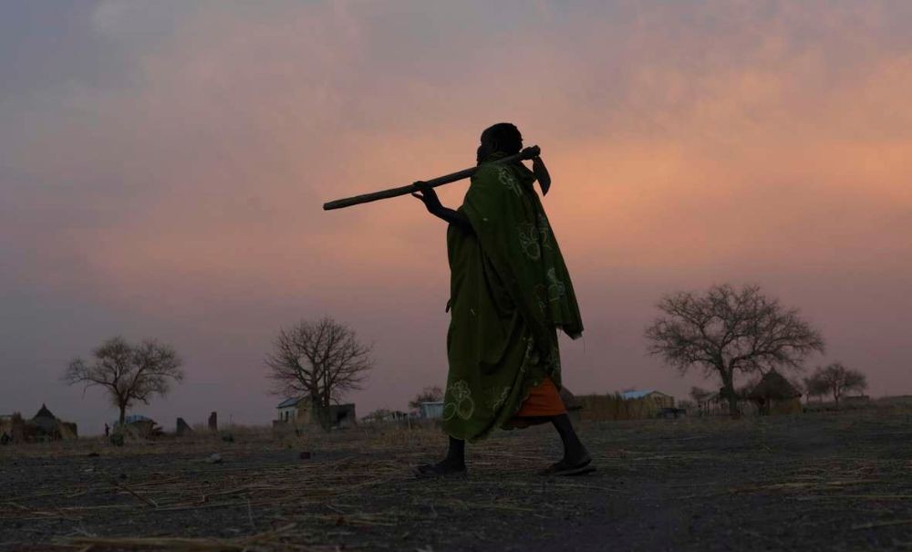 A woman farmer walks from her field to her home near Renk, in South Sudan. (Oxfam)