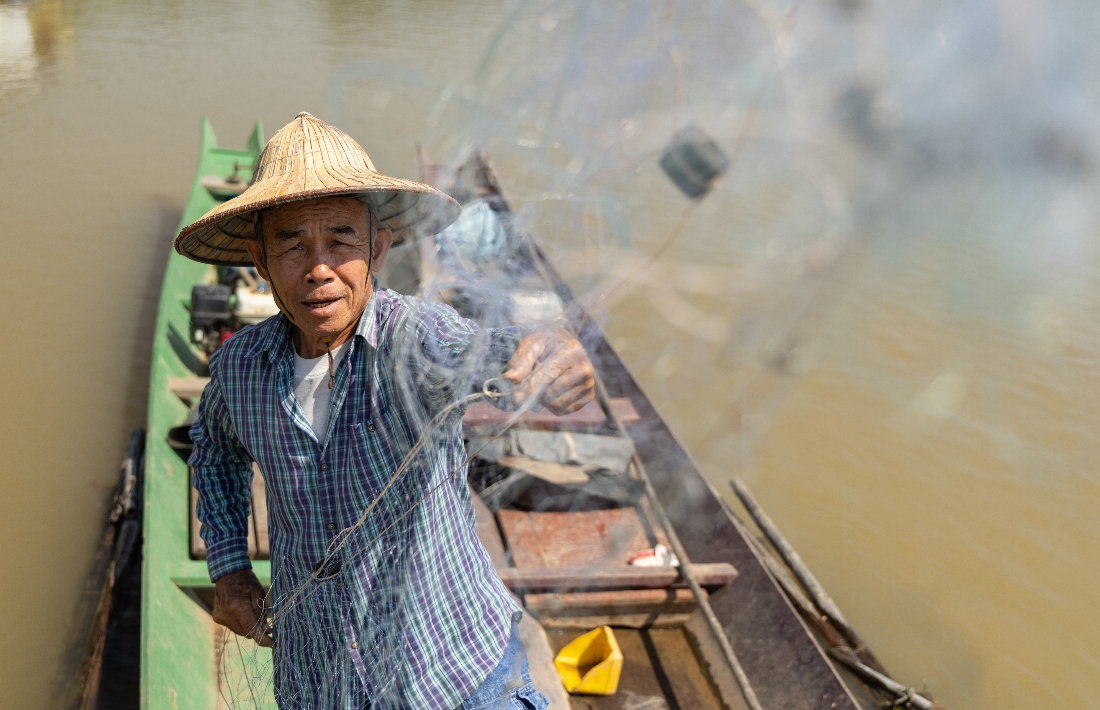 Fisherman Sukjai Yana untangles his net while docked on the Kok River in Chiang Saen, Thailand. (AP)
