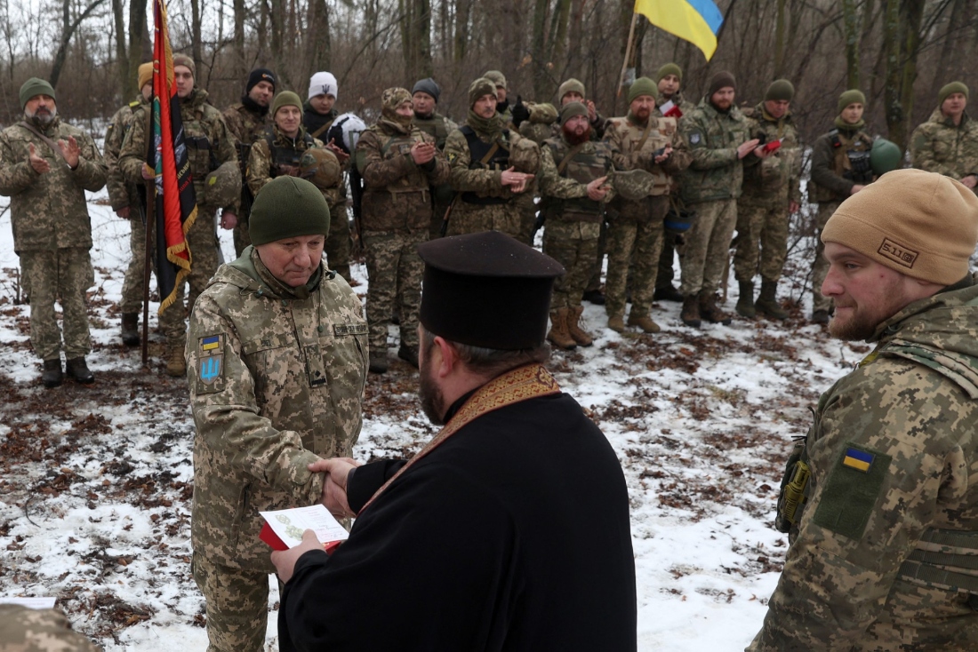 A Ukrainian Orthodox military priest awards artillerymen of the unit of the 14th Prince Roman the Great's Separate Mechanised Brigade as he visits them to maintain their morale near the front line in Kharkiv region, Ukraine. (AFP)