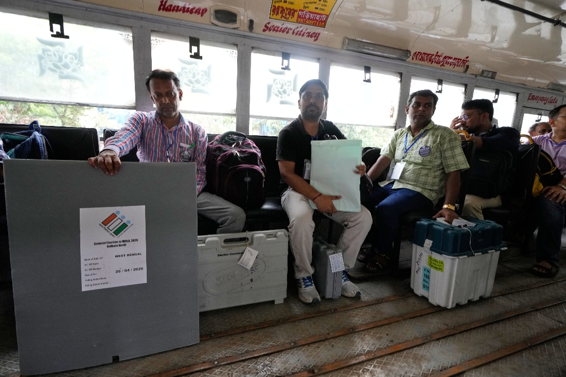 Polling officials with Electronic Voting Machines and other polling materials wait inside a bus for transfer to a polling booth outside a distribution centre ahead of the second phase of elections in West Bengal state, in Kolkata, India. (AP)