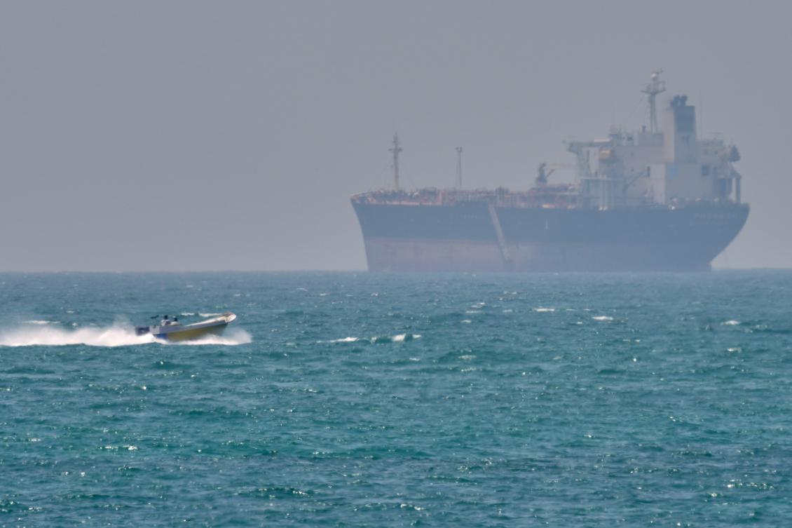 A boat sails past a tanker anchored on the Strait of Hormuz off the coast Qeshm island, Iran this month. (AP/File)