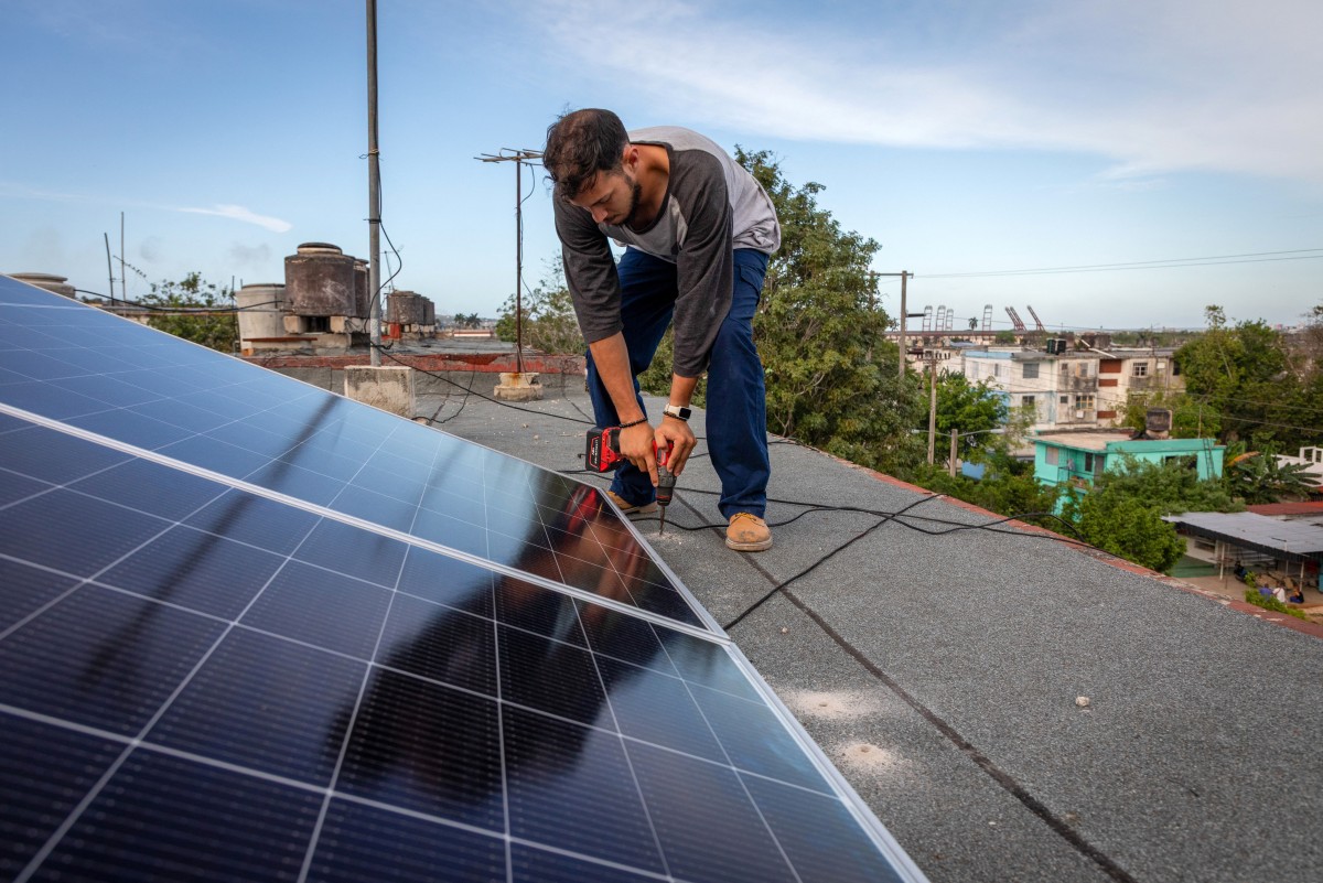 A solar panel specialist installs solar panels on the rooftop of a multi-family building in Matanzas, Cuba, Apr. 13, 2026. (Files / AFP)