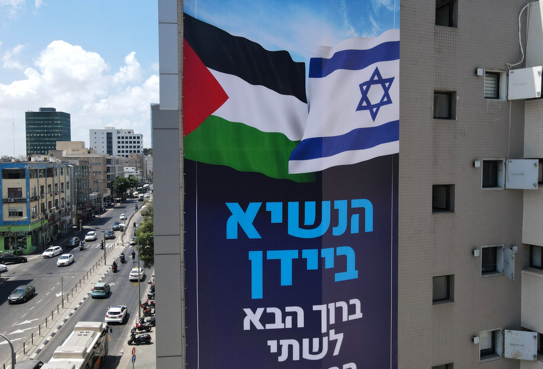 A billboard by Israeli anti-occupation group Peace Now, welcoming US President Joe Biden, hangs on a building in the coastal city of Tel Aviv, ahead of his visit this week, July 11, 2022. (Files / AFP)