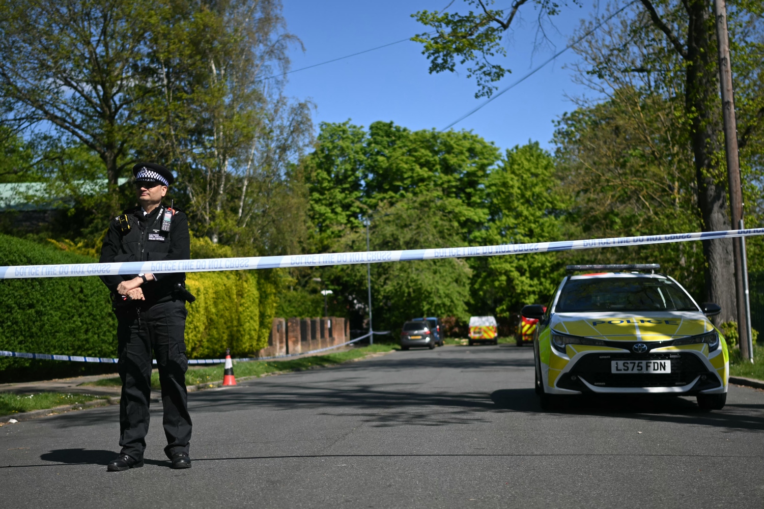 A police officer stands inside a cordon near the scene of an arson attack at Kenton United Synagogue. April 19, 2026 (AFP)