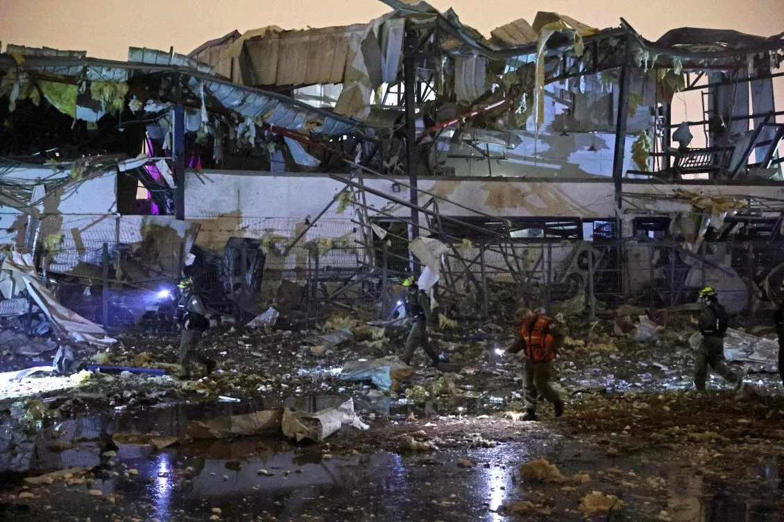 Israeli security forces and first responders inspect the site of an Iranian strike that hit a residential neighborhood in Petah Tikva on April 2, 2026. (AFP)