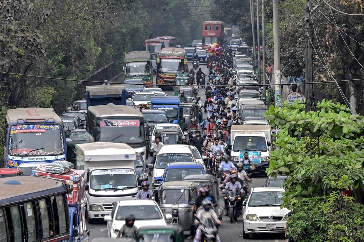 People wait in a queue, right, to refuel their vehicles near a fuel station in Dhaka on March 8, 2026. (AFP)