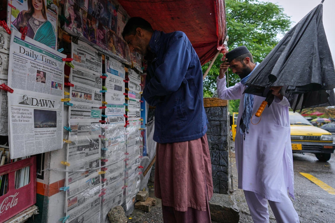 Pakistanis read morning newspapers, covering headlines news regarding United States Israel Iran war, at a stall in Islamabad, Pakistan, Wednesday, April 8, 2026. (AP Photo/Anjum Naveed)
