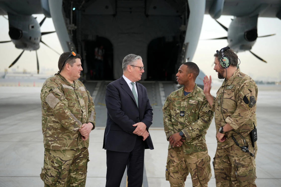 Britain’s Prime Minister Keir Starmer speaks to members of the aircrew before boarding a military plane in Abu Dhabi, UAE. (Reuters)