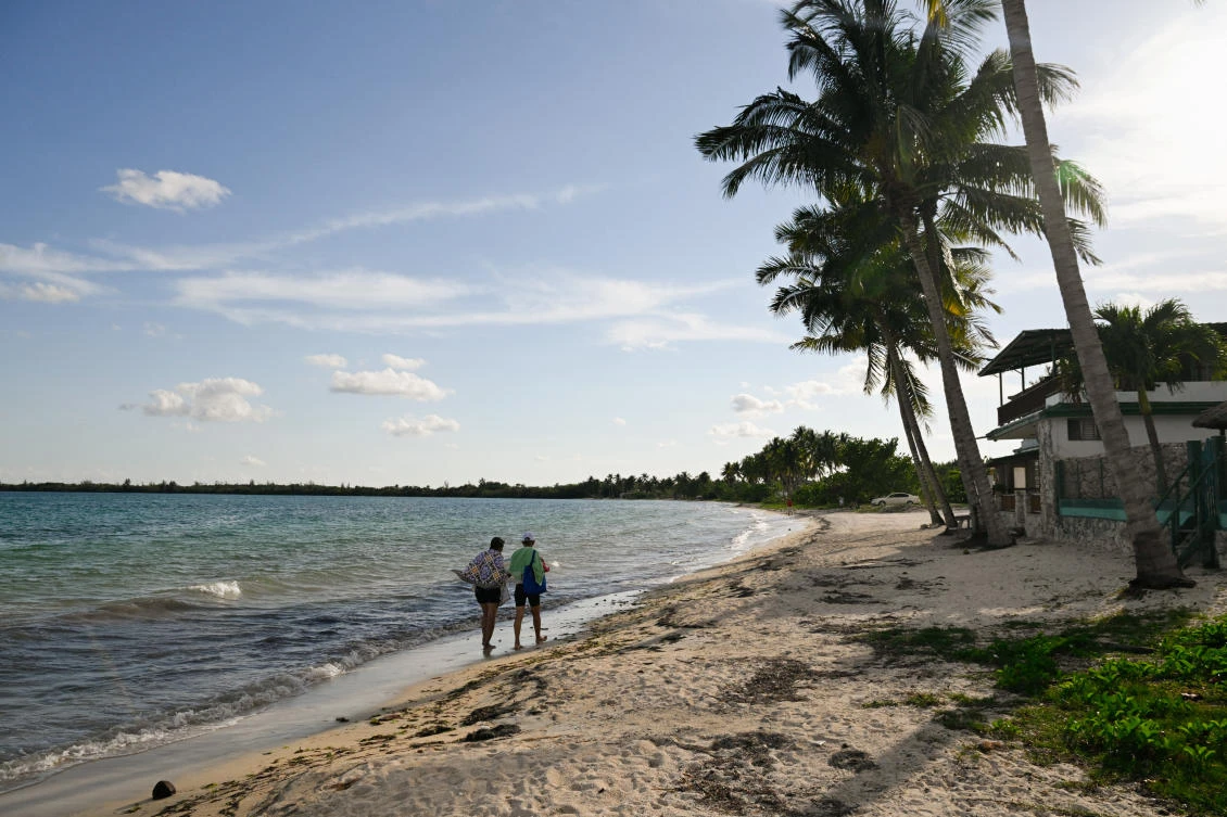 People walk near rental homes as Cuba's top tourist destinations remain deserted amid power and fuel shortages under U.S. sanctions, as international tourist arrivals plunged 56 per cent in February from a year earlier, in Playa Larga, Cienaga de Zapata, Cuba, April 7, 2026. REUTERS/Norlys Perez