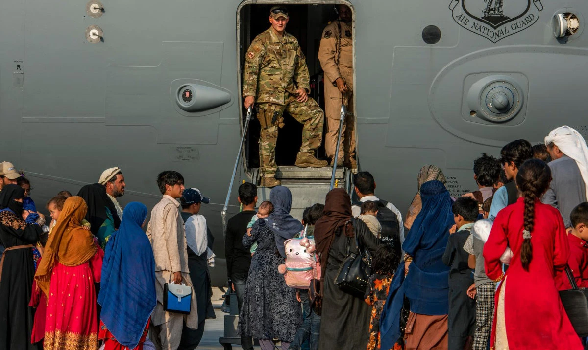 In this Aug. 22, 2021 file photo provided by the US Air Force, service members stand at a doorway as Afghan evacuees prepare to board an aircraft, Aug. 22, 2021, at Al Udeid Air Base, Qatar. (AP/File)
