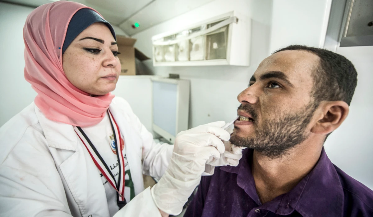 An Egyptian medical staffer takes oral samples from a labourer undergoing examination for Hepatitis C, at the construction site of Egypt's new ‘administrative capital’, in Cairo. (AFP file photo)