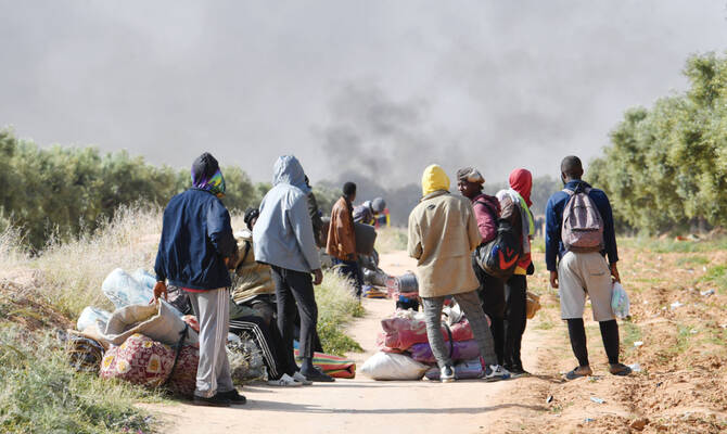 Migrants leave from a camp for undocumented migrants at Al-Amra on the outskirts of Tunisian port city of Sfax. (AFP)