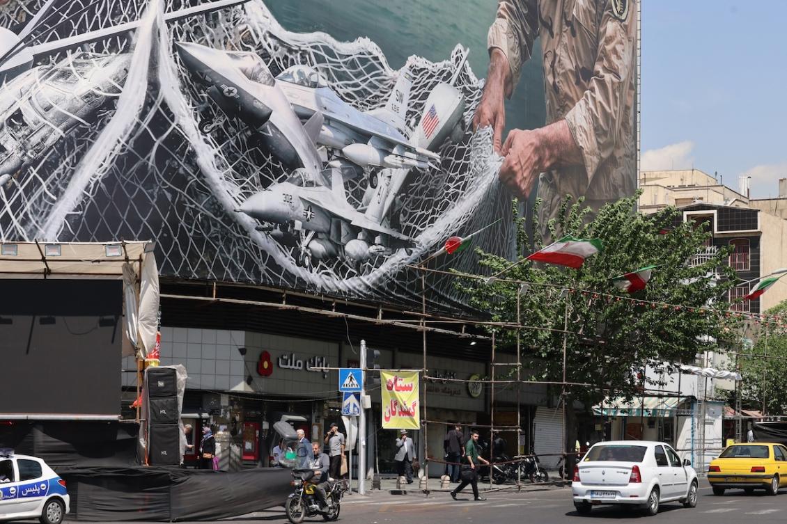 Vehicles drive past a giant billboard reading "The Strait of Hormuz remains closed" at the Revolution Square in Tehran on April 28, 2026. (FILE/AFP)