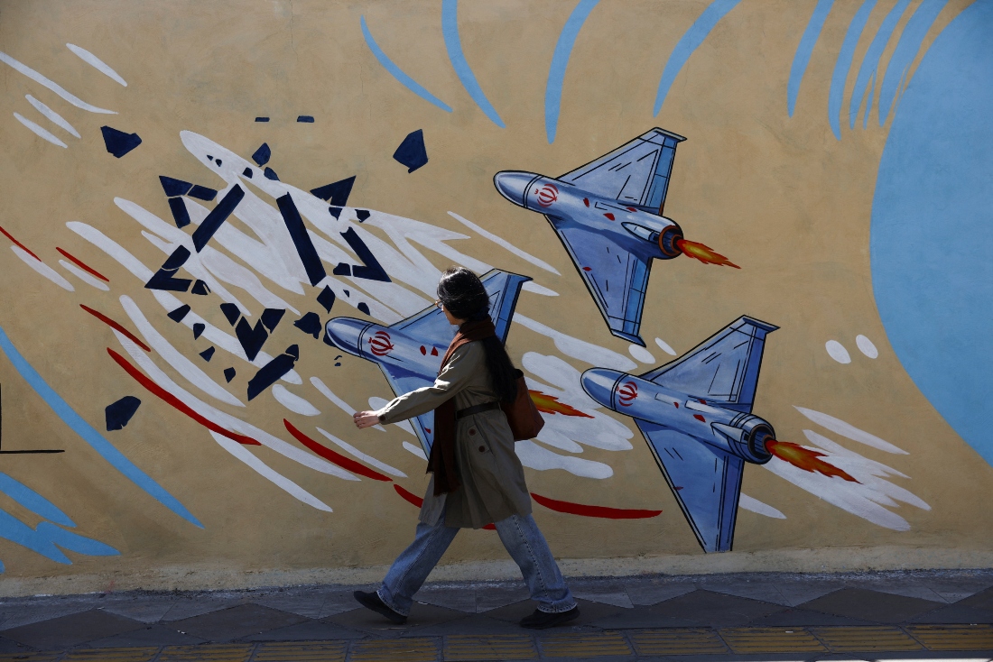 A woman walks past an anti-Israel mural in Iran as US President Donald Trump’s administration argued that the war in Iran has already ended because of the ceasefire that began in early April. (Reuters/File Photo)