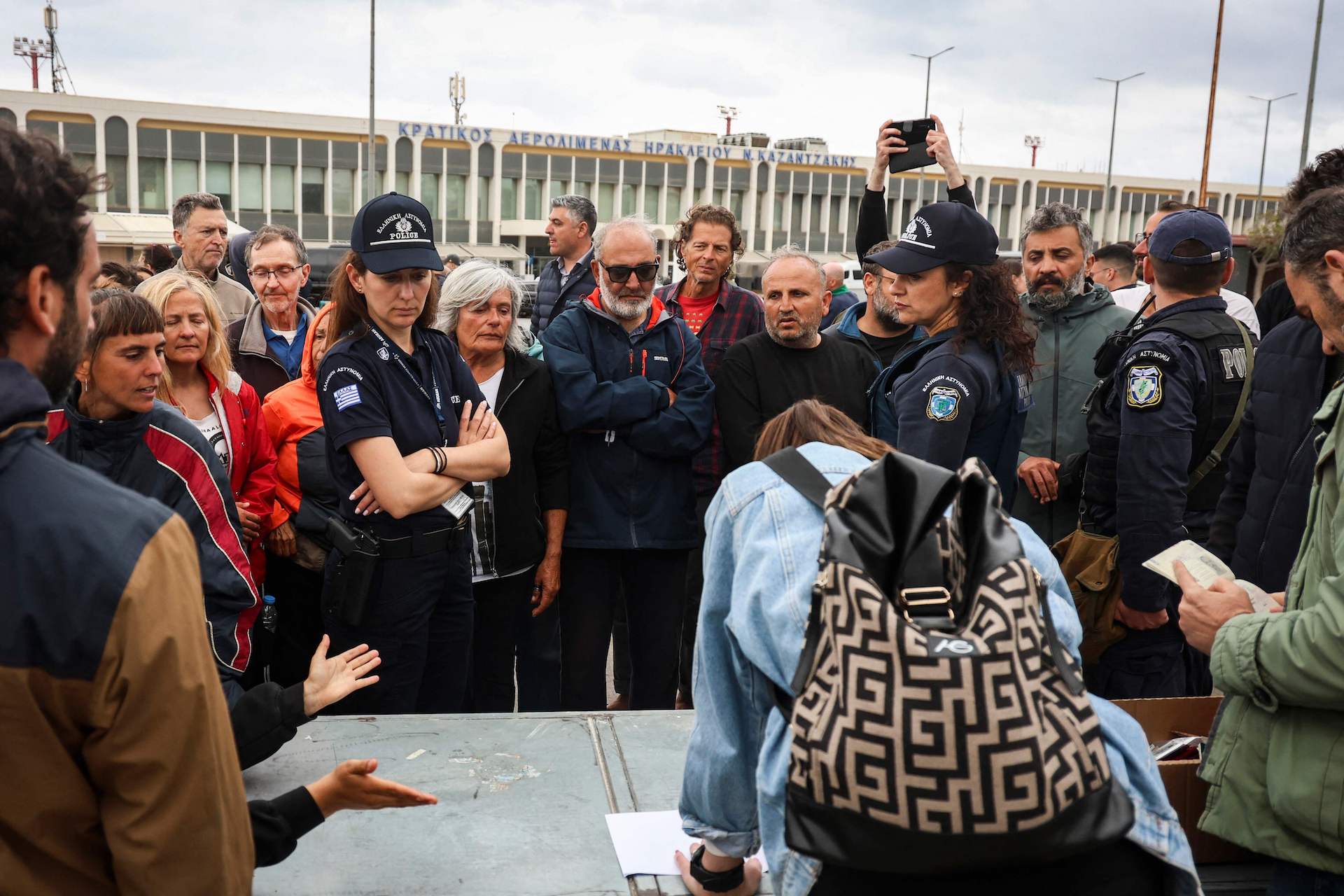Police officers watch members of the Global Sumud Flotilla vessels, intercepted by the Israeli Navy in international waters, demonstrating in the town of Ierapetra in the island of Crete, Greece, on May 1, 2026. (AFP)