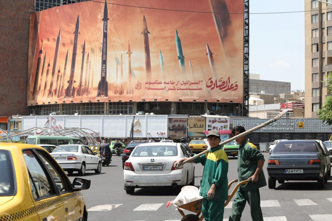 Above, motorists drive their vehicles past a billboard depicting Iranian missiles in Tehran on April 20, 2024. (AFP file photo)