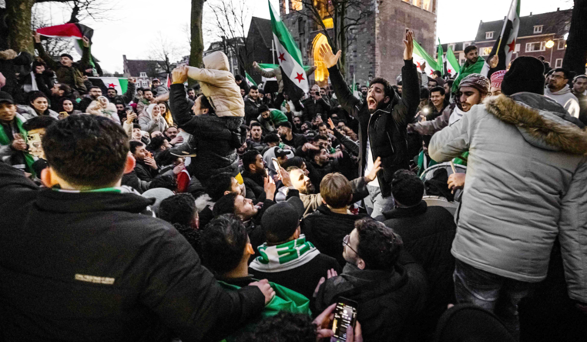 Protesters wave Syrian opposition flags as they gather to celebrate the fall of long-time ruler Bashar al-Assad after rebel fighters took control of the Syrian capital Damascus overnight, in Utrecht on December 8, 2024. (AFP)