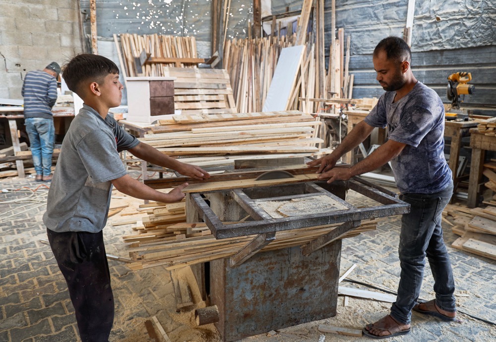 Palestinian carpenter Mohammed Wafi builds furniture from recycled wooden pallets in his workshop amid shortages of materials in Khan Younis, in the southern Gaza Strip. (Reuters)