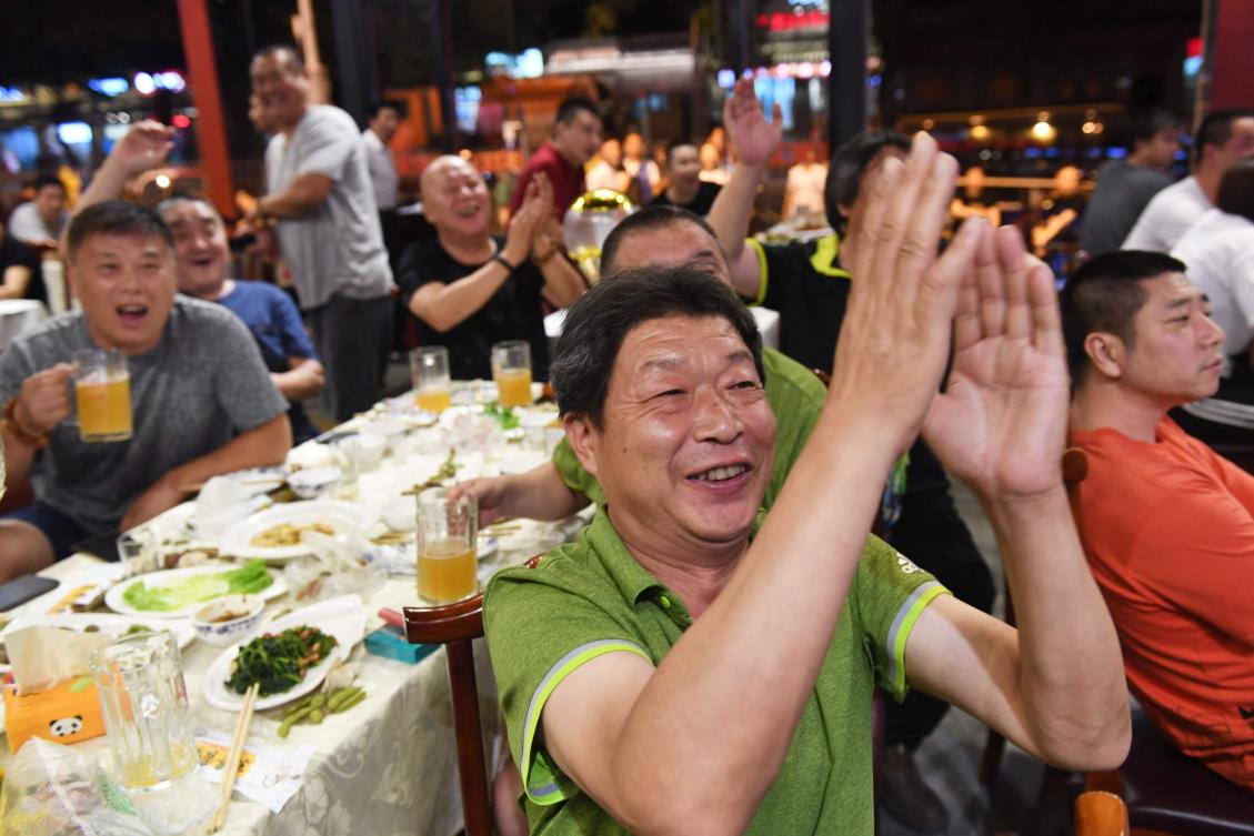 Football fans cheer while watching the 2018 Russia World Cup football match between Brazil and Mexico on a TV screen in a restaurant in Beijing on July 2, 2018. (AFP file photo)