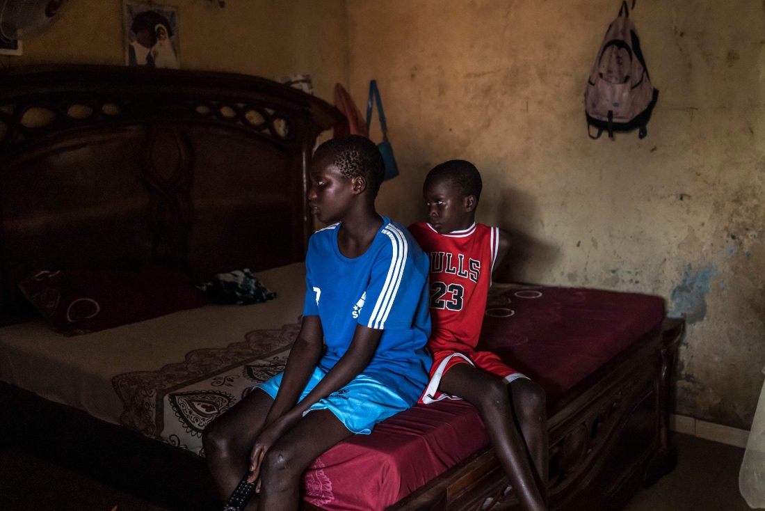 Fallou and Bara watch TV at their home in Mbour, Senegal. (AFP)
