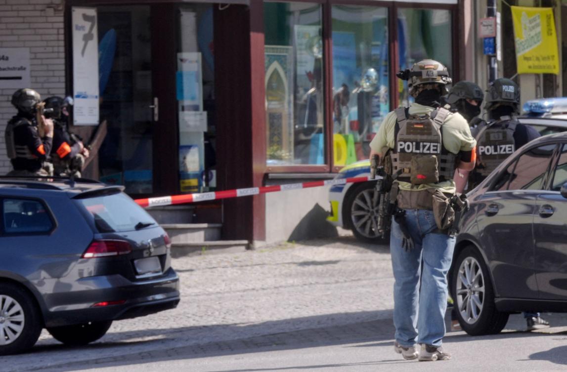 Police stand in a cordonned off area near a bank where suspects have taken multiple hostages in the western German town of Sinzig, on May 8, 2026. (Photo by Thomas Frey / dpa / AFP)