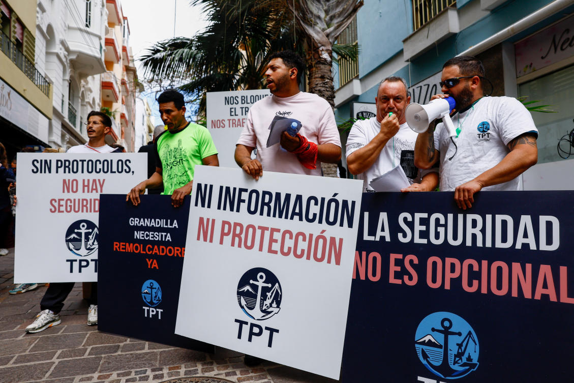 Demonstrators hold placards during a protest by port workers over lack of information ahead of the arrival of the MV Hondius, following a deadly hantavirus outbreak on board the ship, in Santa Cruz de Tenerife, May 8, 2026. (Reuters)