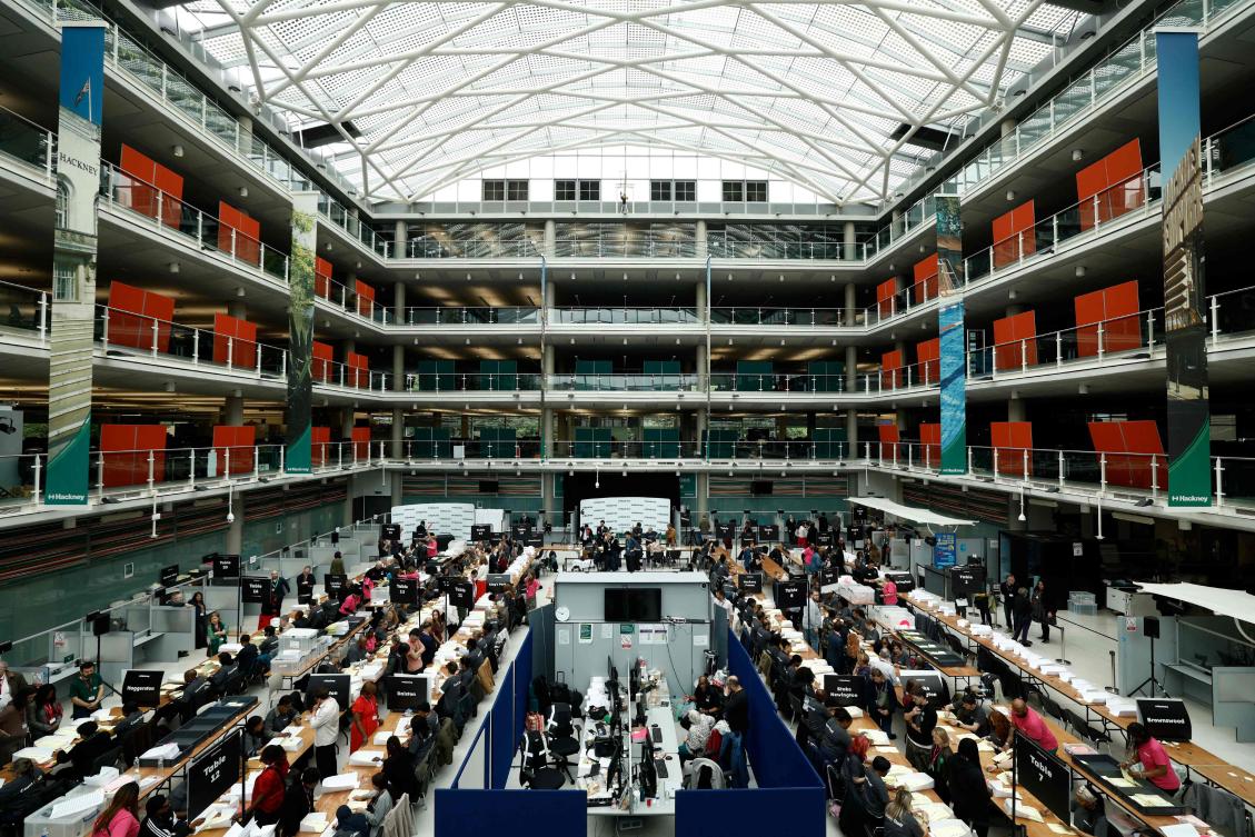 Staff count ballots the morning after local elections at a vote-counting centre inside the count centre for Hackney, north east London on May 8, 2026. (AFP)