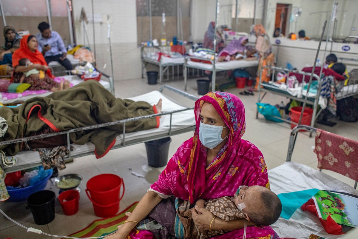 A woman holds a child diagnosed with measles inside a pediatric ward at the Bangladesh Shishu Hospital and Institute in Dhaka on May 6, 2026. (AFP)