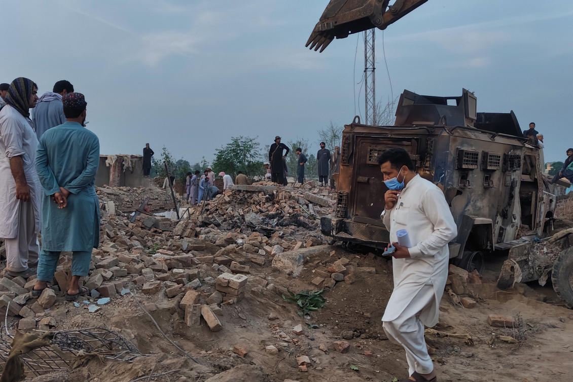 Police officers and local residents examine the site of overnight suicide bombing at a security post in Fatah Khel, in Bannu, a district in Pakistan’s Khyber Pakhtunkhwa province bordering Afghanistan on May 10, 2026. (AP)