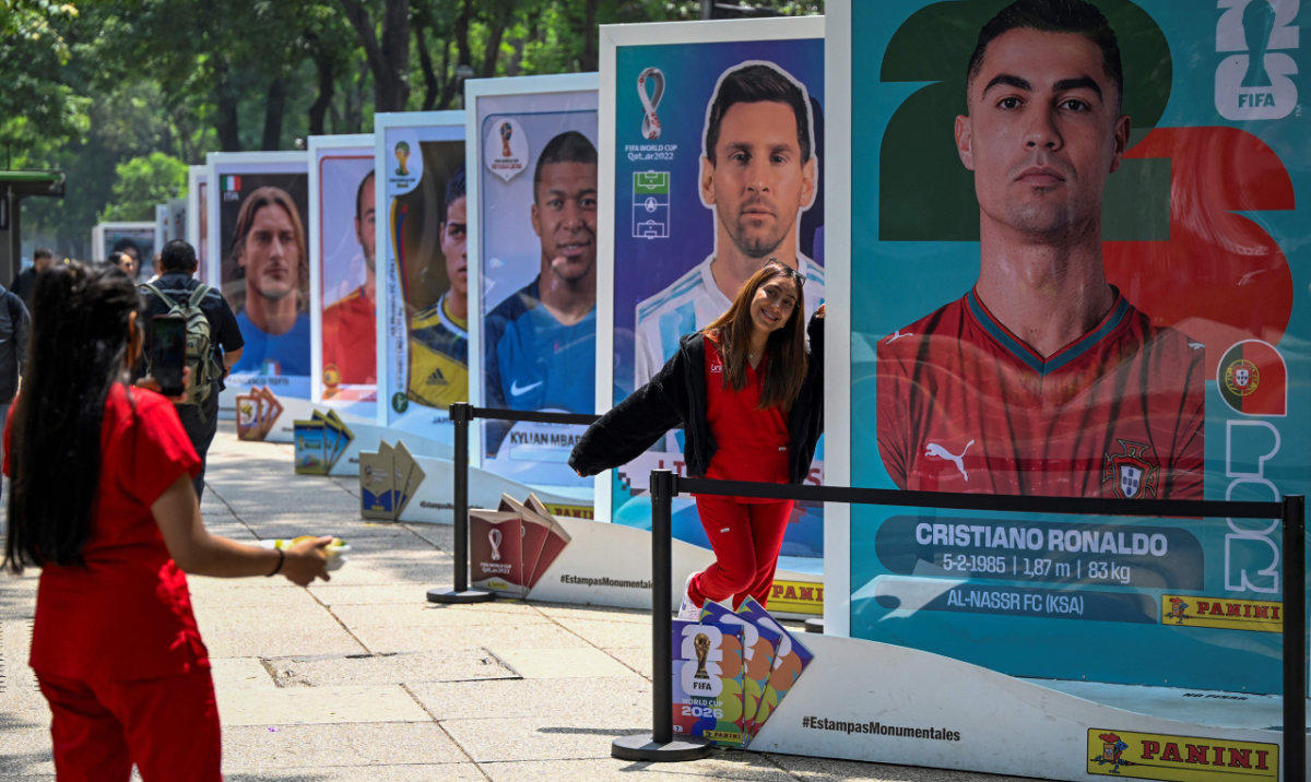 A woman poses with the image of Portuguese footballer Cristiano Ronaldo during an exhibition of the Panini World Cup Album at the Reforma Avenue in Mexico City on May 11, 2026, one month ahead of the opening match of the FIFA World Cup 2026 between Mexico and South Africa. (AFP)