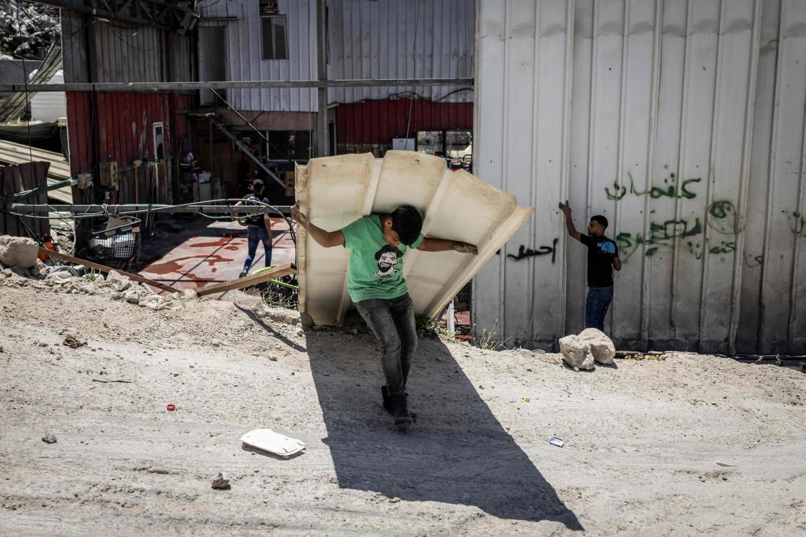 A young Palestinian worker dismantles his family’s car wash ahead of the arrival of an Israeli army demolition team, in the Israeli-occupied West Bank town of Al-Eizariya, bordering east Jerusalem, on May 11, 2026. (AFP)