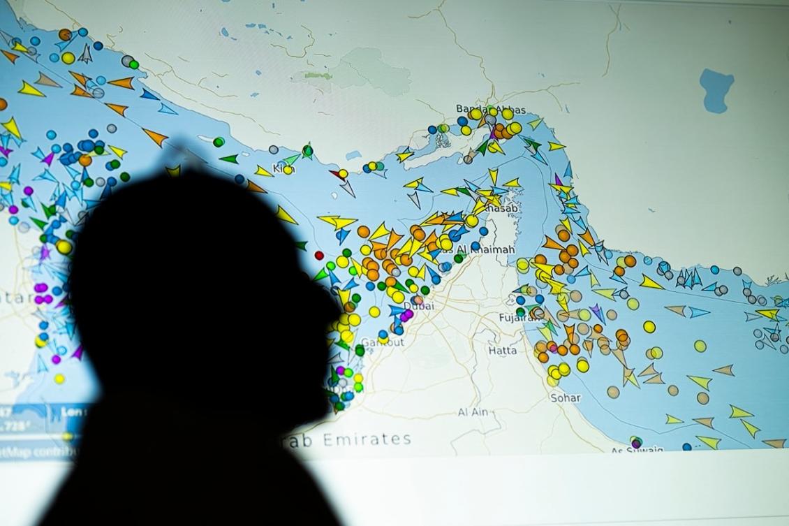 Above, a large screen displays vessel movements in the Strait of Hormuz on a ship-tracking website on May 4, 2026. (AFP)